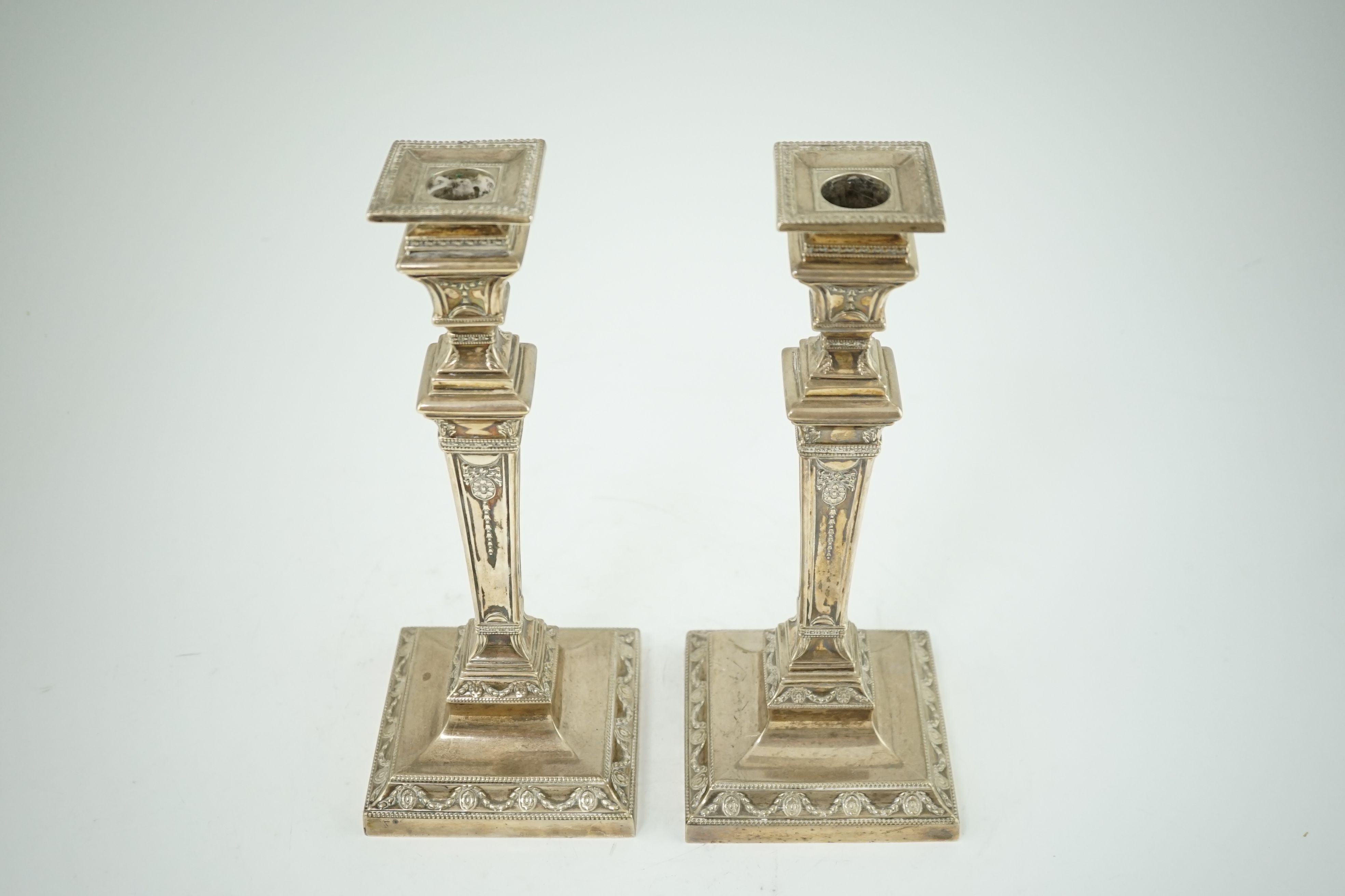 A pair of Edwardian Adam revival silver candlesticks, by Walker & Hall